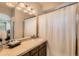 Bathroom with tile countertops, brown cabinets, white shower curtain, and view to the bedroom at 13151 Grant N Cir # C, Thornton, CO 80241