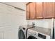 Laundry room features washer, dryer, upper cabinets, and a folding ironing board at 13151 Grant N Cir # C, Thornton, CO 80241