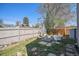 Backyard with fire pit, patio furniture, a garden, privacy fence, and mature landscaping at 1403 Valentia St, Denver, CO 80220