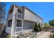 Stylish two-story home with dual balconies, gray siding, garden boxes, and a bright yellow door at 1403 Valentia St, Denver, CO 80220
