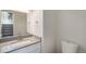 Half bathroom with modern vanity, fixtures, and nearby stairs at 1403 Valentia St, Denver, CO 80220