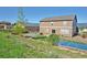 Back exterior view featuring a well-maintained yard with patio and outdoor features at 735 Woodmoor Acres Dr, Monument, CO 80132