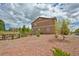 A spacious backyard with a wood fence, natural landscaping, and mature trees at 735 Woodmoor Acres Dr, Monument, CO 80132