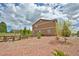 A house with neutral siding, surrounded by a stone yard with a wood rail fence at 735 Woodmoor Acres Dr, Monument, CO 80132
