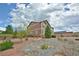 A spacious backyard with a gravel pathway, natural landscaping, and a wood fence at 735 Woodmoor Acres Dr, Monument, CO 80132