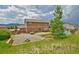 A well kept backyard with a gravel area, fire pit, and lush green grass and mountain views at 735 Woodmoor Acres Dr, Monument, CO 80132