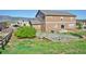 Expansive backyard featuring a patio area with firepit, hot tub, and lush landscaping at 735 Woodmoor Acres Dr, Monument, CO 80132