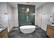 Bright bathroom with a stand-alone soaking tub, green accent wall, and elegant tile at 735 Woodmoor Acres Dr, Monument, CO 80132