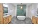 A luxurious bathroom featuring dual vanities, a freestanding tub, a glass-enclosed shower, and a tile floor at 735 Woodmoor Acres Dr, Monument, CO 80132