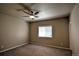 A simple bedroom with a ceiling fan, neutral paint, and a window for natural light at 735 Woodmoor Acres Dr, Monument, CO 80132
