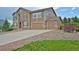 View of a multi-story house with a three-car garage and a well-maintained driveway with decorative rock at 735 Woodmoor Acres Dr, Monument, CO 80132