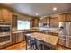 Beautiful kitchen boasts stainless steel appliances, granite counters, and a large center island with bar stool seating at 735 Woodmoor Acres Dr, Monument, CO 80132