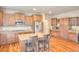 Kitchen showcases hardwood floors, granite countertops, a center island with seating, and stainless steel appliances at 735 Woodmoor Acres Dr, Monument, CO 80132
