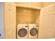Bright laundry room with white washer and dryer and shelving for optimal organization at 735 Woodmoor Acres Dr, Monument, CO 80132