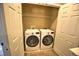Functional laundry room features a white washer and dryer set, plus a wire rack for storage at 735 Woodmoor Acres Dr, Monument, CO 80132