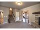 A neutral living room features a stone fireplace, plush carpet and direct access to the staircase at 735 Woodmoor Acres Dr, Monument, CO 80132