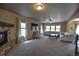 A spacious living room features a stone fireplace, plush carpet, and a comfortable sectional sofa at 735 Woodmoor Acres Dr, Monument, CO 80132