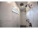 Modern walk-in shower with marble tile, a window, and sleek fixtures at 735 Woodmoor Acres Dr, Monument, CO 80132