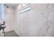 Bright shower with marble-like tile, a window, and updated hardware at 735 Woodmoor Acres Dr, Monument, CO 80132