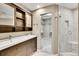 Bathroom with double sink vanity, walk-in closet, and tiled glass-enclosed shower, modern fixtures at 8747 E Dry Creek Rd # 1623, Englewood, CO 80112