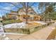 Two-story home with tan siding, brick accents, and landscaped front yard with retaining wall and bare trees at 8747 E Dry Creek Rd # 1623, Englewood, CO 80112