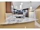 Modern kitchen featuring granite countertops, dark wood cabinets, and stainless steel appliances at 8747 E Dry Creek Rd # 1623, Englewood, CO 80112