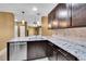 Well-lit kitchen with stainless steel appliances, dark cabinetry, and pendant lighting over the countertops at 8747 E Dry Creek Rd # 1623, Englewood, CO 80112