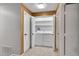 View of a stacked laundry unit inside of a closet with standard white doors and matte black hardware at 8747 E Dry Creek Rd # 1623, Englewood, CO 80112