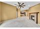 Living room featuring a fireplace, ceiling fan, and an open floor plan that extends into the kitchen and dining area at 8747 E Dry Creek Rd # 1623, Englewood, CO 80112