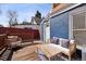 Cozy backyard deck with cushioned seating, table, and a view of the property's exterior at 1144 S Logan St, Denver, CO 80210