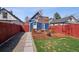 Backyard featuring a patio area, green lawn, landscaping, and a view of the property's exterior at 1144 S Logan St, Denver, CO 80210
