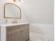 Bathroom features a modern vanity with gold hardware, a gold trimmed mirror, and a tub at 1144 S Logan St, Denver, CO 80210