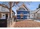 Charming blue home featuring a well-manicured front yard with outdoor seating and a welcoming facade at 1144 S Logan St, Denver, CO 80210