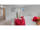 Neutral-toned bedroom with carpeted floors featuring bright pops of red and metallic pillows and decorative vase at 7507 Braun St, Arvada, CO 80005