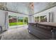 Relaxing sunroom features a modern hot tub, wood plank ceiling, and sliding doors to a landscaped backyard at 7507 Braun St, Arvada, CO 80005