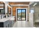 Bright bathroom features dual sinks, stone floors, glass shower and scenic mountain views from private balcony at 1651 Pine Valley Rd, Evergreen, CO 80439
