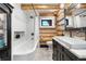 Charming bathroom boasts log accents, vanity, white tile shower, and modern fixtures creating a cozy atmosphere at 1651 Pine Valley Rd, Evergreen, CO 80439