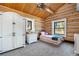 Adorable bedroom showcases log walls, built-in wardrobe, and soft lighting creating a cozy and inviting retreat at 1651 Pine Valley Rd, Evergreen, CO 80439