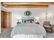Comfortable bedroom with neutral decor, beam ceiling and a cozy seating area at 1651 Pine Valley Rd, Evergreen, CO 80439