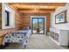 Cozy bedroom with log walls, access to a private balcony offering mountain views, and white accent furniture at 1651 Pine Valley Rd, Evergreen, CO 80439