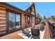 Exterior of log home with deck featuring seating and beautiful mountain views at 1651 Pine Valley Rd, Evergreen, CO 80439