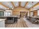 Open kitchen and dining area with log beam ceilings, hardwood floors, and large island at 1651 Pine Valley Rd, Evergreen, CO 80439
