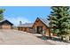 Charming log cabin featuring a stone foundation and peak roof plus Adirondack chairs on a gravel front yard at 1651 Pine Valley Rd, Evergreen, CO 80439