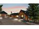 Charming log home with a black roof and two inviting blue chairs on a paved drive way at 1651 Pine Valley Rd, Evergreen, CO 80439