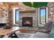 Close up of stone fireplace in log home with hardwood floors and views of the mountains at 1651 Pine Valley Rd, Evergreen, CO 80439