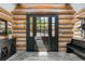 Foyer featuring a tiled floor, log walls, a wooden front door and wooden bench at 1651 Pine Valley Rd, Evergreen, CO 80439