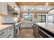 Well-lit kitchen with stainless steel appliances, stone countertops, and a breakfast bar at 1651 Pine Valley Rd, Evergreen, CO 80439