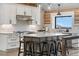 Bright kitchen featuring a large island, modern fixtures, and wood beam accents at 1651 Pine Valley Rd, Evergreen, CO 80439