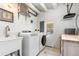 Bright laundry room with washer, dryer, utility sink, wood countertops, patterned floors, and white walls at 1651 Pine Valley Rd, Evergreen, CO 80439
