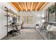 Cozy living room with wood beam ceiling, white walls, carpet flooring, and a gray couch near a window at 1651 Pine Valley Rd, Evergreen, CO 80439